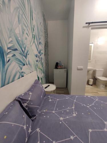 ein Schlafzimmer mit einem Bett und einer blau-weißen Wand in der Unterkunft Habitación cactus, entrada privada y baño privado en suite by flamingo house, no fumadores in Arrecife