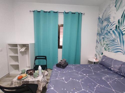 Schlafzimmer mit blauen Vorhängen, einem Bett und einem Fenster in der Unterkunft Habitación cactus, entrada privada y baño privado en suite by flamingo house, no fumadores in Arrecife