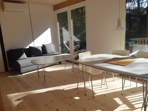 a living room with two tables and a couch at Guest house in the Forest in Vejby