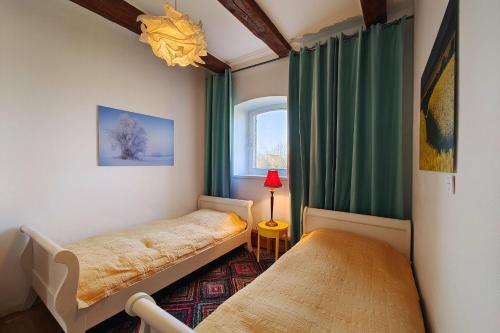 a small bedroom with two beds and a window at FeWo Loft Vorwerk Seehausen - Uckermark - mit großer Terrasse in Seehausen