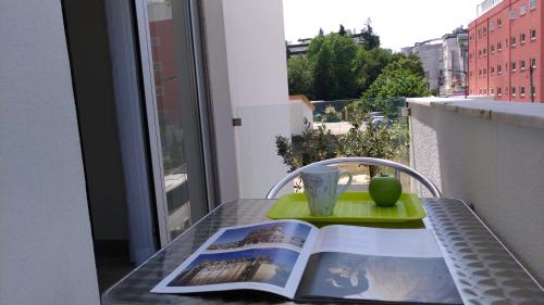 a table with a book and a cup on a balcony at StaynFeel 02 in Fátima