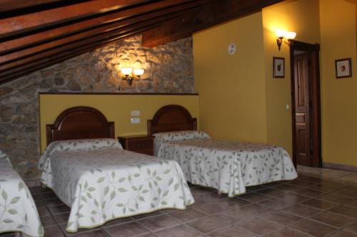 two beds in a room with yellow walls at La Venta de Quijas in Quijas