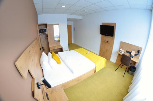 a small room with a bed and a tv at Hotel Am Markt in Karlsruhe
