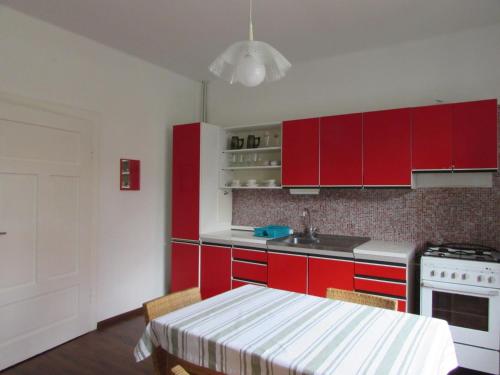 a kitchen with red cabinets and a table with chairs at Dům u rybníka in Nýdek