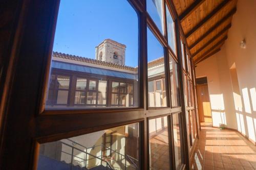 une vue extérieure d'un bâtiment avec une tour d'horloge dans l'établissement Albergo Palazzo Sant'Anna, à Gerace