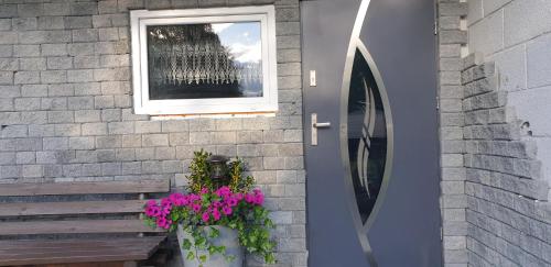 a building with a window and a bench and flowers at Studio 5 in Dalen