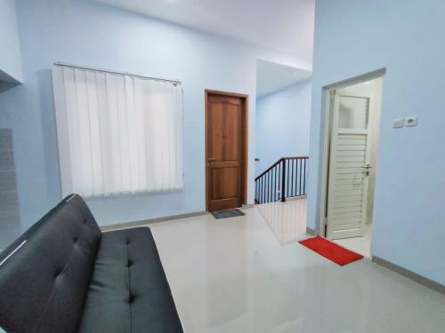 a living room with a black couch and a door at Huize Silitonga in Malang
