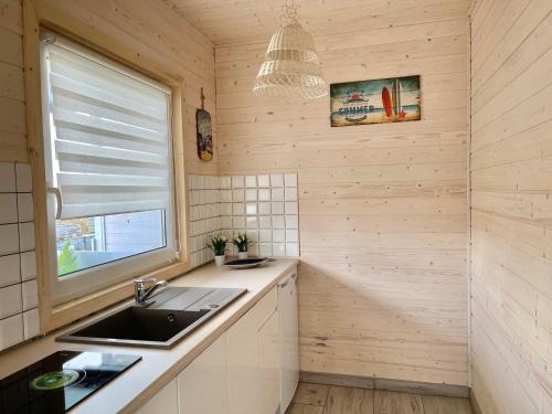 a kitchen with a sink and a window at Domki Kapitana in Bobolin