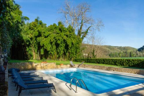 a swimming pool with lounge chairs next to at DordogneView in Calès