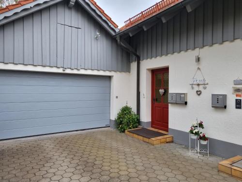un garaje con una puerta roja en una casa en Bergliebe, en Germaringen