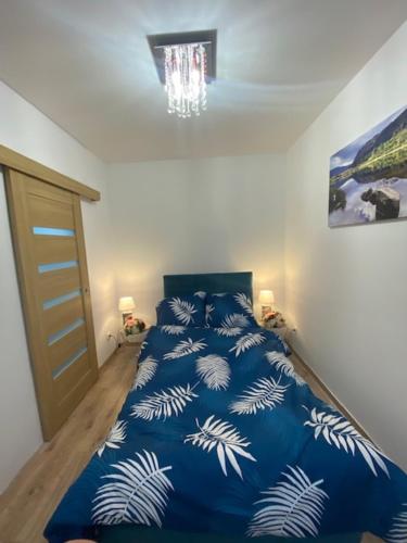 a bedroom with a bed with a blue comforter at Apartament Karpacz 2- pokojowy in Karpacz