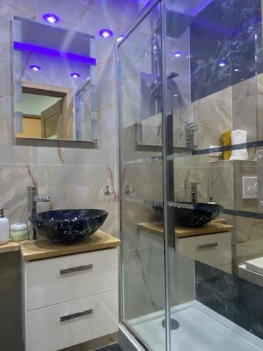 a bathroom with a glass shower and a sink at Apartament Karpacz 2- pokojowy in Karpacz