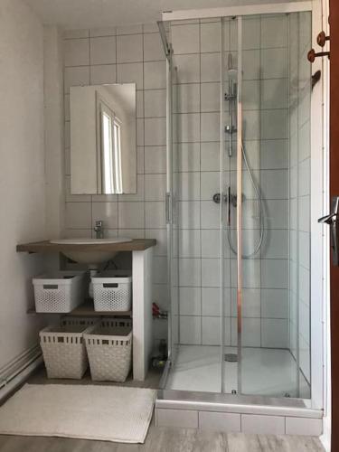 une salle de bain avec une douche avec un lavabo et un miroir dans l'établissement le toit d'Albatre, au Tréport