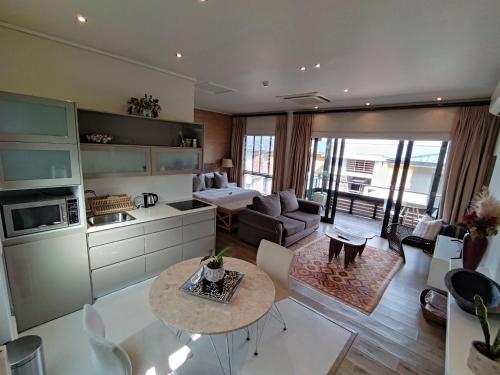 a kitchen and living room with a table and a couch at 210 Gallery Luxury Studio Apartment in Knysna