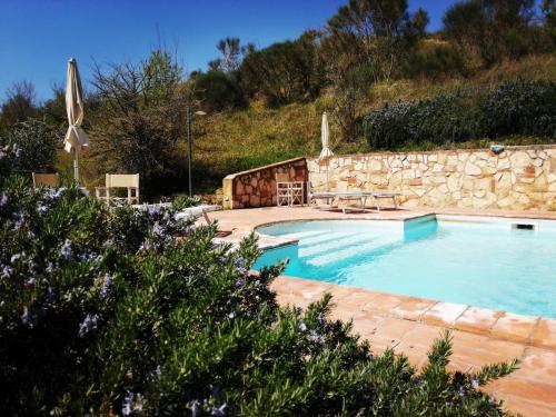 una gran piscina con una pared de piedra al lado en Viva House, en Montaione