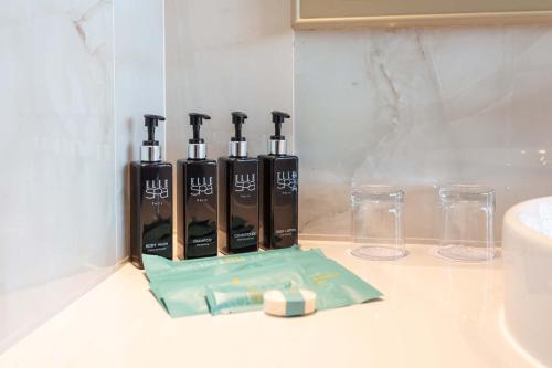 a group of four bottles of soap on a counter at Laguna Grand Hotel & Spa Songkhla in Songkhla