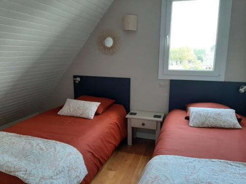 deux lits dans une petite pièce avec une fenêtre dans l'établissement Chambres d'hôtes de Ty Guen, à Trédarzec