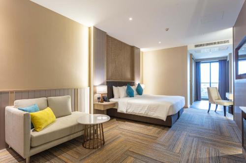 a hotel room with a bed and a couch at Laguna Grand Hotel & Spa Songkhla in Songkhla