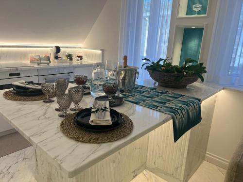 un bancone della cucina con piatti e bicchieri di MAISON LADY CLAUDIA LUXURY ACCOMMODATION a Sorrento