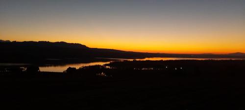 a sunset over a body of water with the sun setting at Chata Stylchyn in Kluszkowce