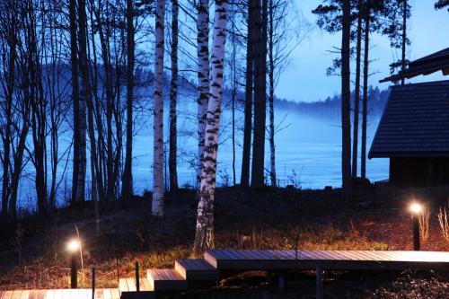 a bench in front of a view of a lake at Saimaanranta Resort by Anttolanhovi in Mikkeli