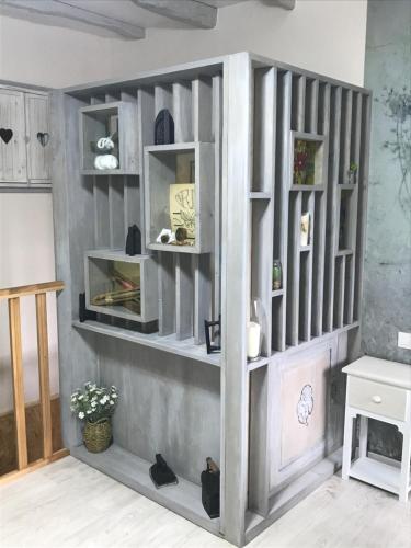 a book shelf in a living room with a table at "La chambre des TISSERANDS" in Ménil-Hubert-sur-Orne