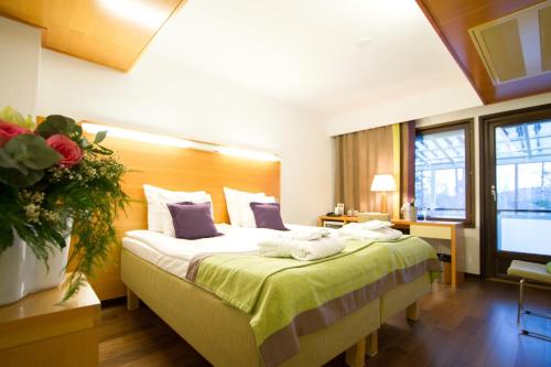 a hotel room with a large bed with towels on it at Saimaanranta Resort by Anttolanhovi in Mikkeli