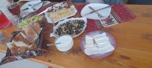 a wooden table with plates of food on it at AMOJ B&B and Guest house in Alaverdi