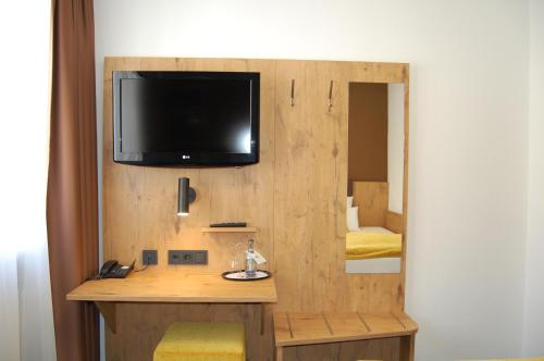 a room with a desk with a tv on the wall at Hotel Am Markt in Karlsruhe