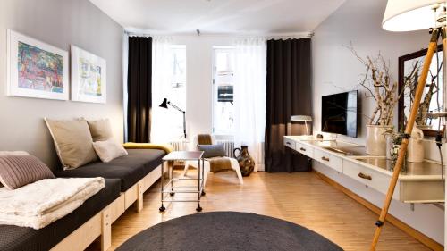 ein Wohnzimmer mit einem Sofa und einem TV in der Unterkunft Gelber Löwe - Ferienwohnung in der Erfurter Altstadt in Erfurt