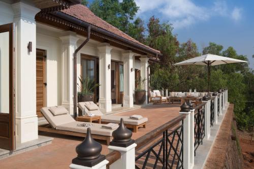 an outdoor deck of a house with chairs and an umbrella at Kahani Paradise in Gokarna