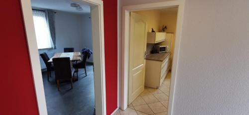 a kitchen and dining room with a table and a kitchen and a room with at Ferienhaus Heidegeist in Soltau