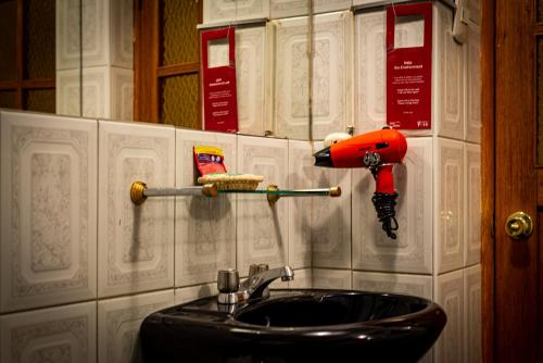 a bathroom with a sink and a shelf with books at Casona Santa Catalina Cusco in Cusco