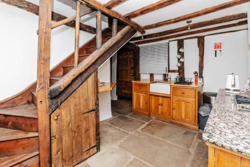 eine Küche mit Holzschränken und einer großen Holztür in der Unterkunft 1400 Cottage An enchanting unique stay in Henley on Thames