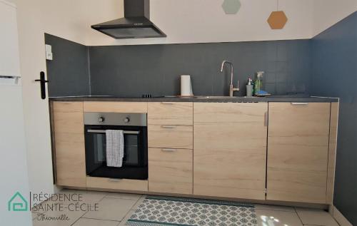 a kitchen with a sink and a stove at Résidence Sainte-Cécile in Thionville