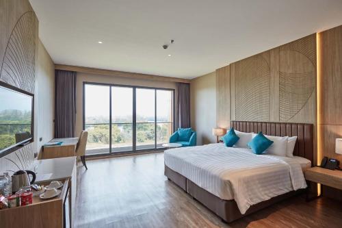 a hotel room with a bed and a desk and a window at Laguna Grand Hotel & Spa Songkhla in Songkhla