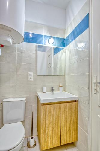 une salle de bain avec un lavabo, des toilettes et un miroir dans l'établissement Le Grand Bleu de Bergerac, à Bergerac