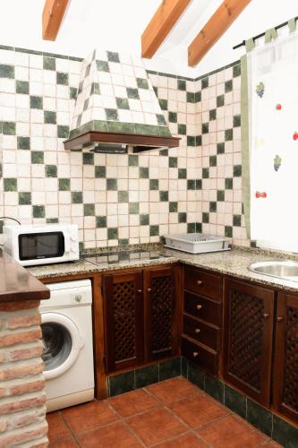 a kitchen with a washing machine and a sink at Casas Arena y Mar in Zahora