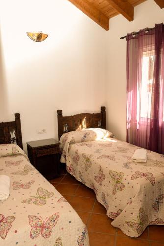 a bedroom with two beds and a window at Casas Arena y Mar in Zahora
