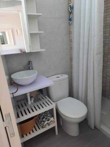 uma casa de banho com um WC branco e um lavatório. em Apartamento en Arenal a 5 minutos de la playa em Arenal d'en Castell