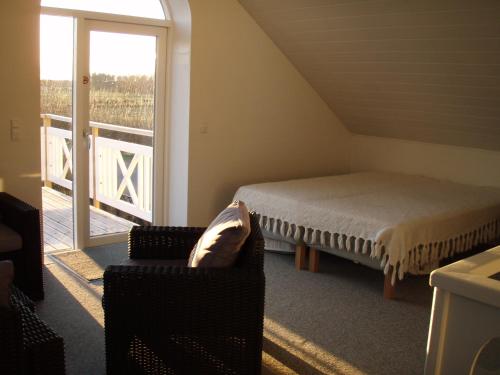 a bedroom with a bed and a chair and a window at Idyllic country house in Vadum