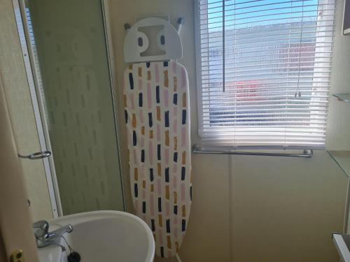 a shower curtain in a bathroom with a window at 8 Berth Coral Beach (Mirage Super) in Ingoldmells