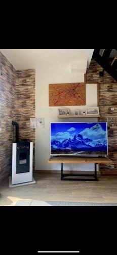 a large flat screen tv in a living room with a stove at Jojo House Les Damps n 12 in Les Damps