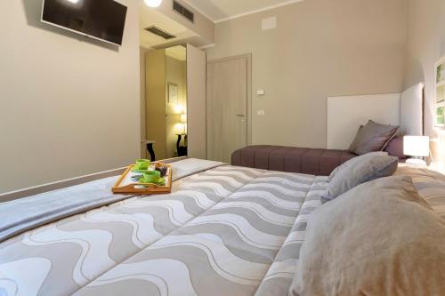 a large bed with a tray on top of it at Musica Guest House in Alghero