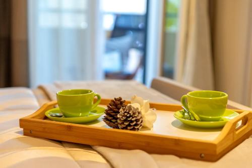 a tray with two coffee cups and a pine cone at Musica Guest House in Alghero