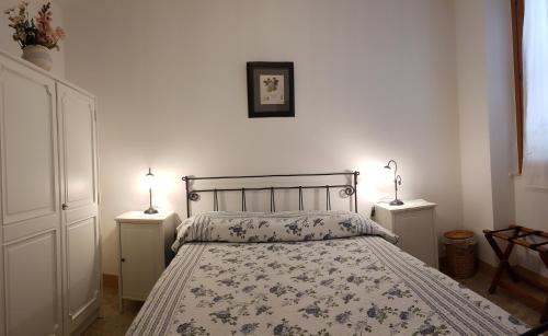 a bedroom with a bed with two night stands and two lamps at Palazzo Fassitelli in Cossignano