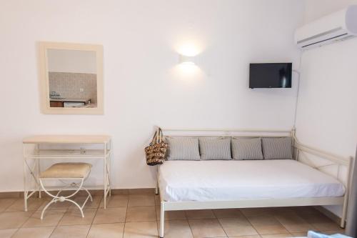a small bedroom with a bed and a desk at Joanna Apart - Hotel in Grikos