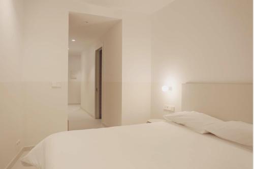 a white bedroom with a white bed and a mirror at HOTEL LA FONDA B&B in Tarazona de Aragón