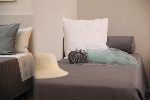 a bed with a bag sitting on top of it at Musica Guest House in Alghero