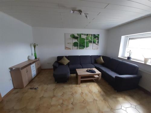 a living room with a blue couch and a table at Ferienwohnung Kleeblatt in Alpen